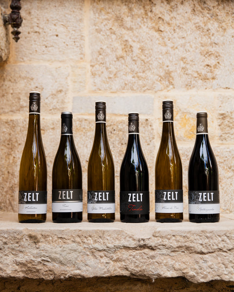 Probierpaket Weingut Zelt Get to Know Zelt Produktfoto 6 Flaschenpaket Wein versandkostenfrei steht auf einer mediteranen steinbank